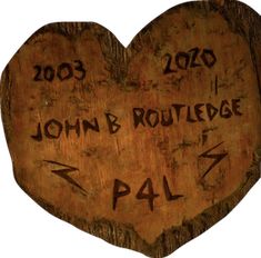 a carved wooden heart with writing on it