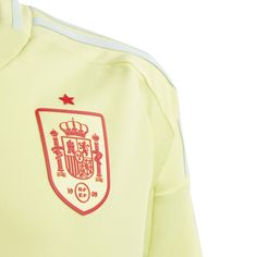 the back of a yellow soccer jersey with red and white trimmings on it