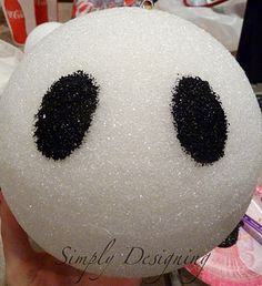 a person holding a white ball with black eyes on it