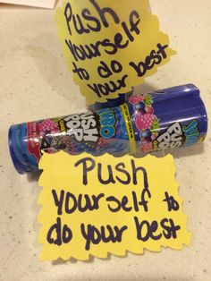 two toothbrushes with writing on them sitting next to a sign that says push yourself and do your best