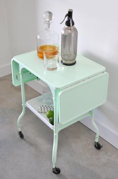 a green table with a glass on it and a bottle sitting on top of it