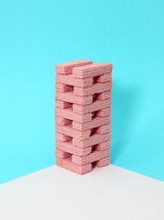 a stack of pink sponges sitting on top of a white table next to a blue wall