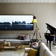 a living room filled with furniture and a piano in front of a large painting on the wall