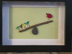 three birds sitting on top of a piece of driftwood in a shadow box frame