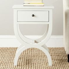 a small white table with a book on top