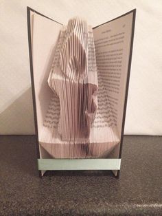 an origami book sculpture is displayed on a table