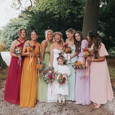 a group of women standing next to each other holding bouquets and flowers in their hands