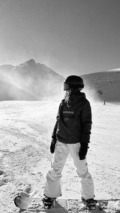 a snowboarder is standing in the snow with his skis on and looking down