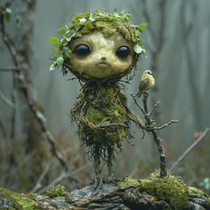 a small doll with leaves on its head and branches around it's body, standing in the woods