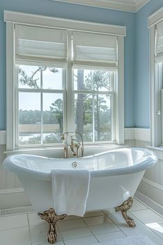 a white bath tub sitting next to two windows