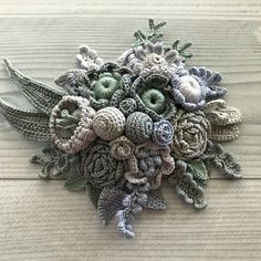 crocheted flowers are displayed on a wooden surface