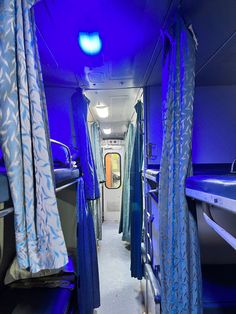 the inside of a bus with blue curtains