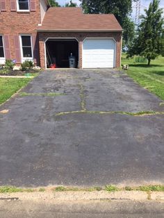 an empty driveway in front of a brick house