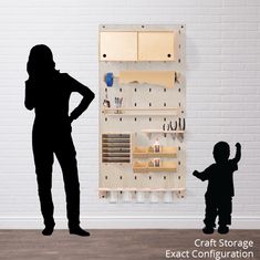 a woman standing next to a child in front of a wall mounted pegboard with letters on it