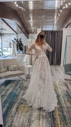 a woman is taking a selfie in her wedding dress at the bridal shop