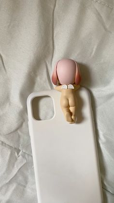 an iphone case with a small doll on it's back and the phone cover is made out of plastic