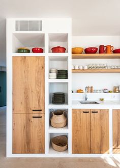 a kitchen with wooden cabinets and white walls