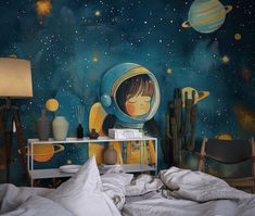 a child's bedroom with a space theme painted on the wall and bedding