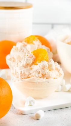 an orange fluff salad in a bowl with marshmallows on the side