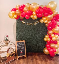 the balloon arch is decorated with gold and red balloons