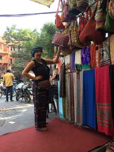 a woman standing in front of a market stall