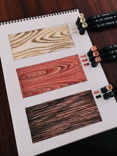 some pencils are sitting on top of a piece of paper with woodgrain