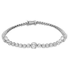 Introducing our stunning tennis bracelet, a timeless embodiment of classic elegance meticulously crafted in 18K white gold. Featuring dazzling round brilliant cut diamonds totaling 1.69 carats, with three diamonds set in prong settings for the illusion of larger stones. The bright white diamonds exhibit G-H color and SI clarity, ensuring remarkable brilliance. With a bracelet length of 7 inches and width of 5.5 mm, weighing 9.17 grams, it offers a substantial yet graceful adornment. Handmade wit Dazzling Platinum Tennis Bracelet With Prong Setting, Diamond White Brilliant Cut Tennis Bracelet, Fine Jewelry Tennis Bracelet With Brilliant Cut, Lab Grown Diamond Bracelet With Prong Setting, Timeless Diamond Tennis Bracelet, Diamond Tennis Bracelet With Brilliant Round Cut, Timeless Diamond Tennis Bracelet With Round Cut, Diamond Tennis Bracelet With Brilliant Cut, Timeless Round Cut Diamond Tennis Bracelet