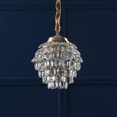 a chandelier hanging from the ceiling in front of a blue wall