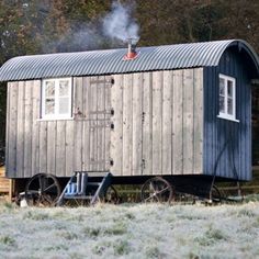 a small wooden cabin sitting in the middle of a field