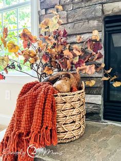 a basket filled with leaves next to a fire place