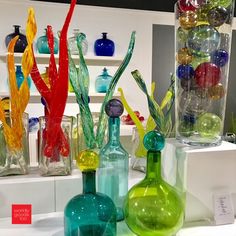 several different colored glass vases on display