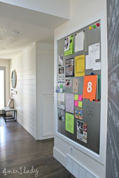 a white wall with magnets and post it notes attached to the back of it