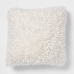 a white pillow with fluffy fur on it