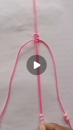 someone is making something with pink string