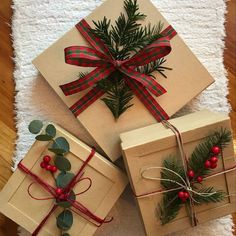 three wrapped presents with red and green bows on them are sitting on a white rug