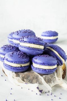 purple macaroons with white frosting and sprinkles