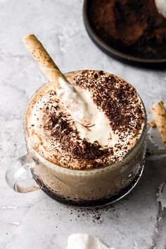 there is a cup of hot chocolate with whipped cream on top and cinnamon sticks sticking out of it