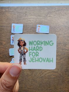 a person holding up a sticker that says working hard for jehovah