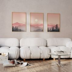 a living room with white furniture and paintings on the wall