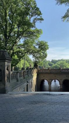 a stone bridge with trees in the background