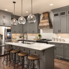 a large kitchen with gray cabinets and stainless steel appliances