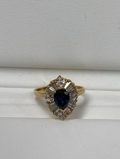 a blue and white diamond ring sitting on top of a box