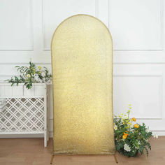 a large gold sequined screen next to some flowers and a white planter