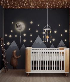 a baby's room decorated in black and white with mountains, stars and moon lights