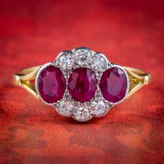 A gorgeous Edwardian inspired cluster ring adorned with three cherry pink Rubies totalling to 1.25ct and six sparkling Old European cut Diamonds with superb SI1 clarity - H colour (approx. 0.30ct total). The gallery is all 18ct with a White Gold face and Yellow Gold band. It's very striking and boasts a wonderful combination of gemstones that complement one another beautifully.  We recommend you insure for £2,000. We can provide a written Valuation on completion of the sale.  WEIGHT: 2.6 grams Classic Ruby Ring With Rose Cut Diamond Cluster, Heirloom Ruby Cluster Ring With Brilliant Cut, Three Stone Cluster Diamond Ring, Ruby Bands, Ruby Rings, Edwardian Style, Gold Face, Edwardian Fashion, European Cut Diamonds