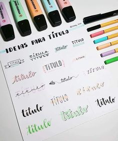 some markers and pens are sitting on top of a sheet of paper with different ink colors