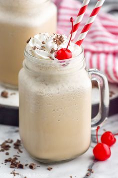 two glasses filled with whipped cream and topped with cherries