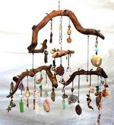 a wind chime hanging from a tree branch filled with glass beads and seashells