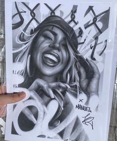 a hand holding up a drawing of a woman with her mouth open and tongue out