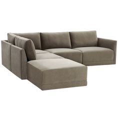 a large sectional couch sitting next to a footstool on top of a white floor